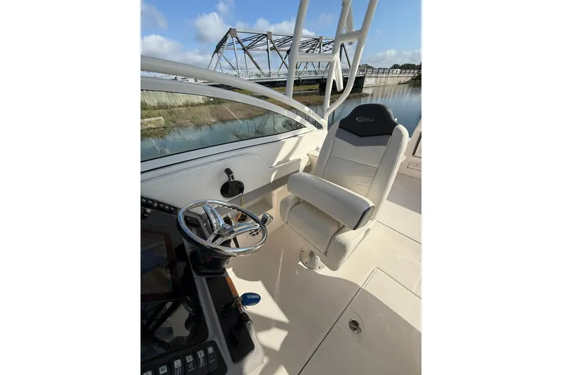 Slide: The Image of 2022 Robalo R247 Dual Console boat interior with steering wheel and captain's chair. - 18