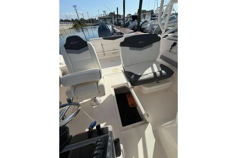 Slide: The Image of 2022 Robalo R247 Dual Console boat interior with seating and helm controls. - 19