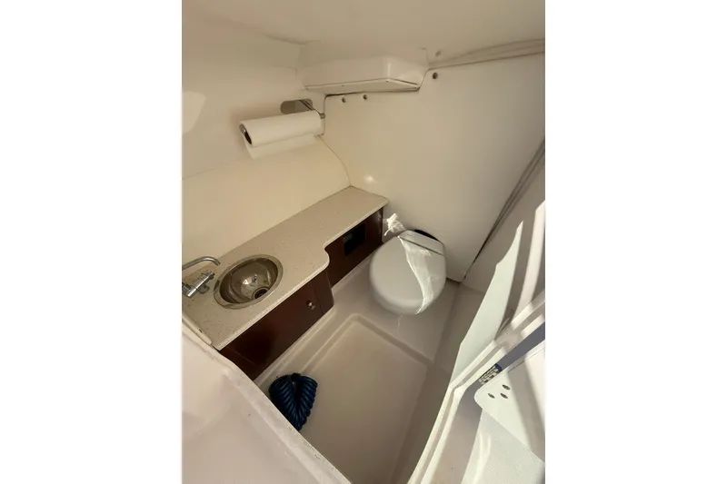 Slide: The Image of 2022 Robalo R247 Dual Console boat interior with sink and toilet. - 20