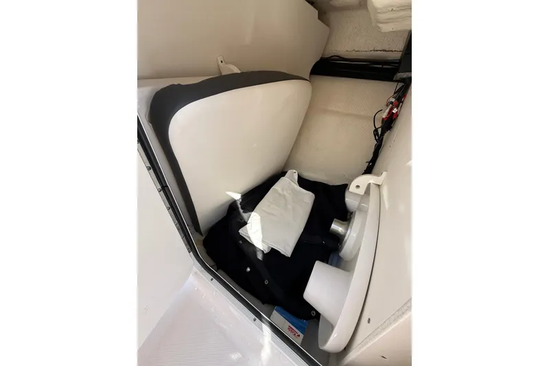 Slide: The Image of 2022 Robalo R247 Dual Console interior storage compartment with seat and equipment. - 21