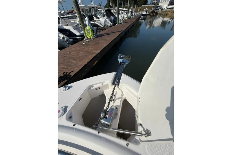 Slide: The Image of 2022 Robalo R247 Dual Console boat with anchor at dockside. - 23