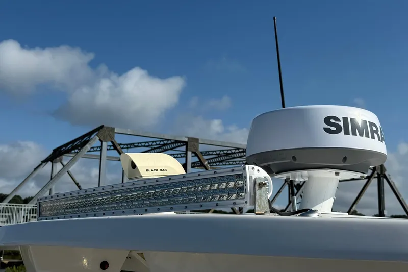 Slide: The Image of 2022 Robalo R247 Dual Console boat with radar and light bar, bridge in background. - 6