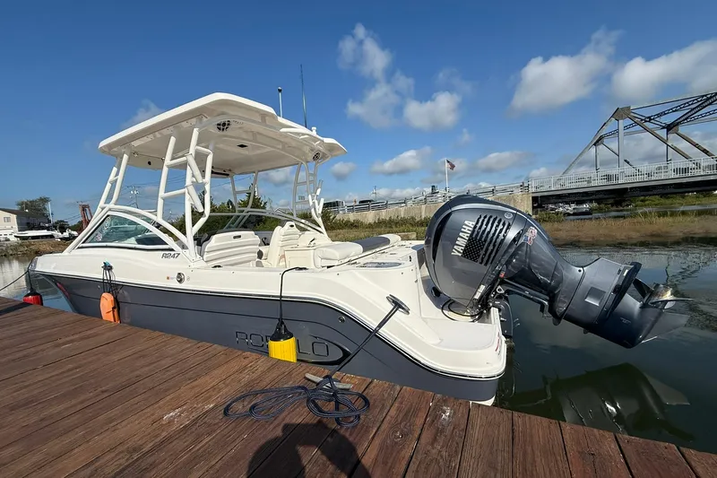 Slide: The Image of 2022 Robalo R247 Dual Console boat docked with Yamaha outboard motor. - 7