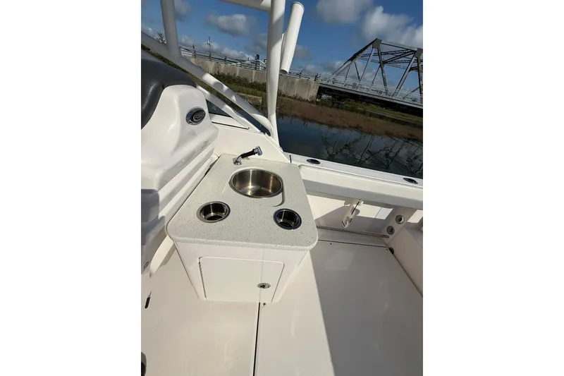 Slide: The Image of 2022 Robalo R247 Dual Console boat with sink and cup holders, near a bridge. - 8