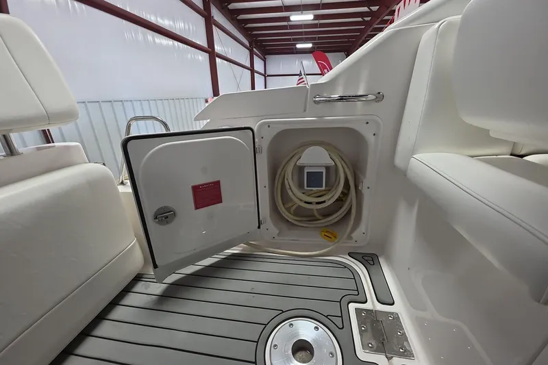 Slide: The Image of 2007 Regal 2860 Window Express boat interior with open storage compartment and coiled hose. - 5