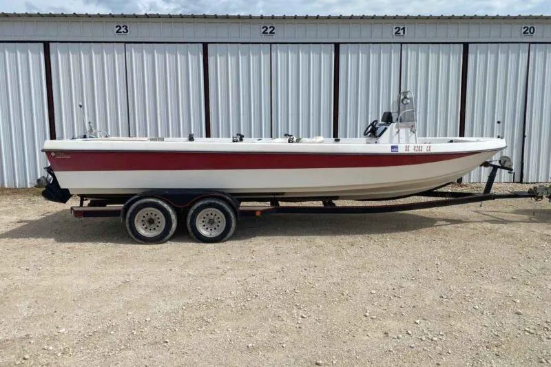 Slide: The Image of 2000 Falcon Striper boat on trailer, parked in front of storage units. - 1