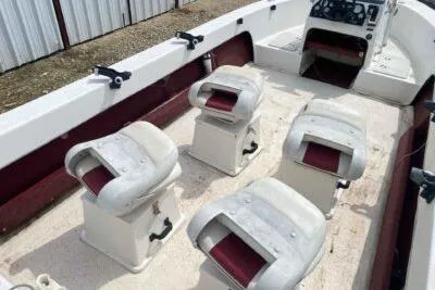 Slide: The Image of 2000 Falcon Striper boat interior with four white seats and red accents. - 13