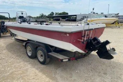 Slide: The Image of 2000 Falcon Striper boat on trailer, red and white design, parked outdoors. - 5