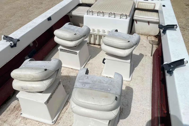 Slide: The Image of 2000 Falcon Striper boat interior with four white cushioned seats and rod holders. - 7