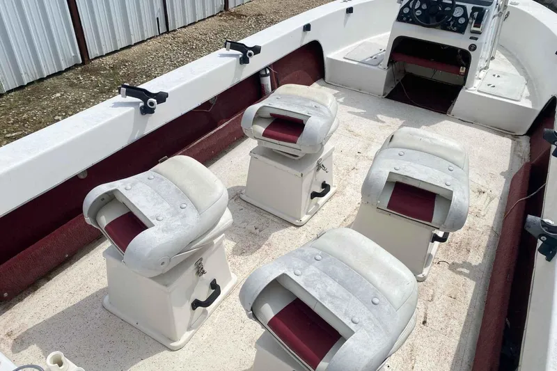 Slide: The Image of 2000 Falcon Striper boat interior with four cushioned seats and steering console. - 8