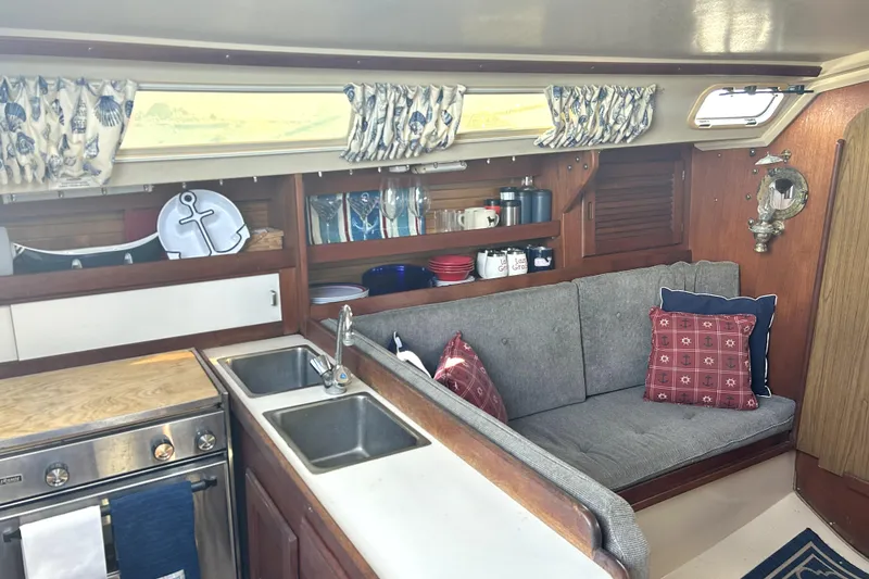 Slide: The Image of Cozy interior of 1987 Catalina 30 Mk II sailboat with kitchen and seating area. - 11