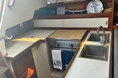 Slide: The Image of 1987 Catalina 30 Mk II yacht kitchen with stove, sink, and storage cabinets. - 18