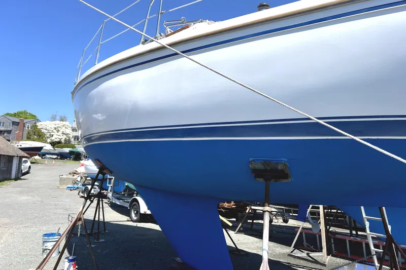 Slide: The Image of 1987 Catalina 30 Mk II sailboat on land, blue and white hull, sunny day. - 2