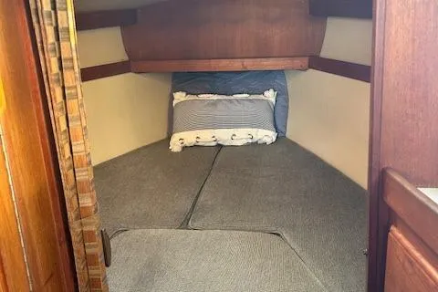 Slide: The Image of 1987 Catalina 30 Mk II cabin interior with cozy bedding and wooden accents. - 21