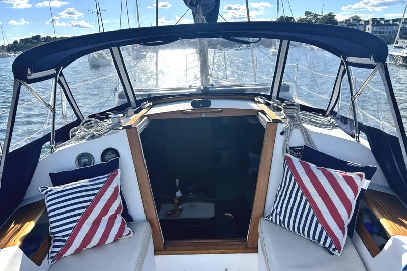 Slide: The Image of 1987 Catalina 30 Mk II sailboat cockpit with striped cushions, docked in sunny marina. - 4