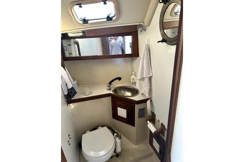 Slide: The Image of Compact bathroom in a 1987 Catalina 30 Mk II sailboat, featuring a sink and toilet. - 7