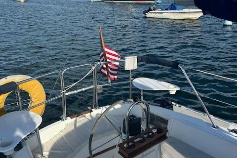 Slide: The Image of 1987 Catalina 30 Mk II sailboat cockpit with American flag on calm water. - 9