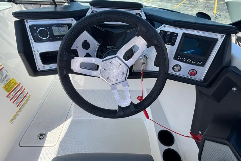 Slide: The Image of Steering wheel and dashboard of a 2015 MasterCraft NXT20 boat, featuring control panels. - 10