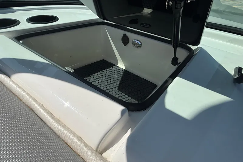 Slide: The Image of Open storage compartment on 2015 MasterCraft NXT20 boat, featuring a hexagonal mat. - 14