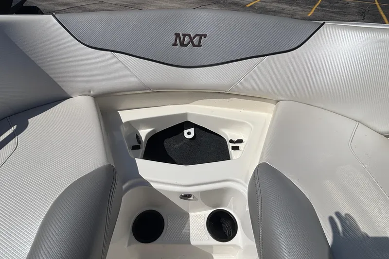 Slide: The Image of 2015 MasterCraft NXT20 boat interior with storage compartment and cup holders. - 19