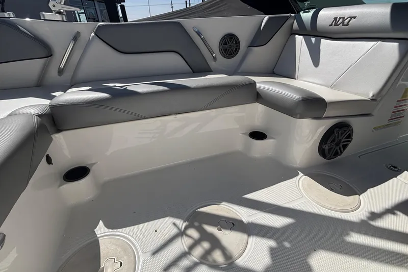 Slide: The Image of 2015 MasterCraft NXT20 boat interior with gray seating and speaker system. - 8
