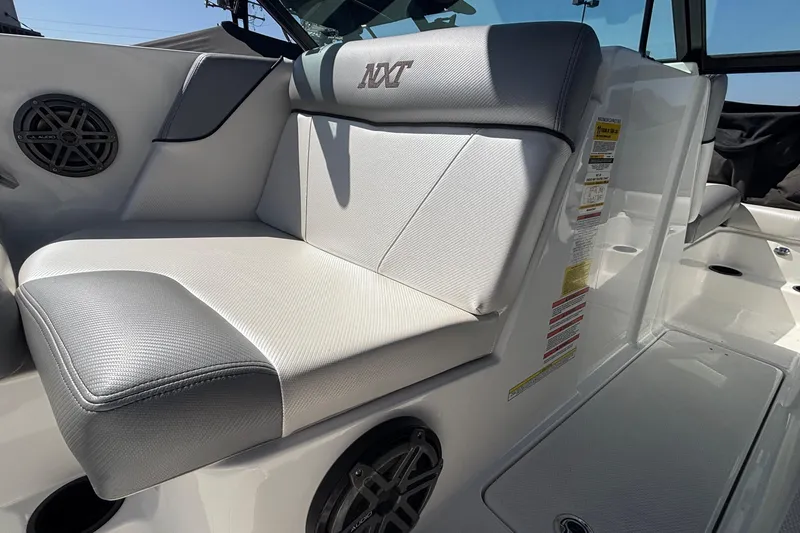 Slide: The Image of 2015 MasterCraft NXT20 boat interior with gray and white seating and speaker system. - 9