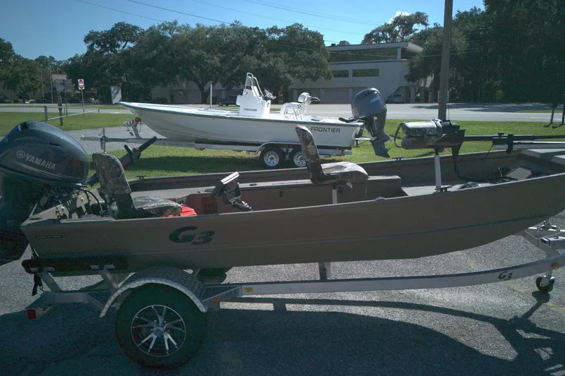 The Image of Boat on trailer with Yamaha motor, G3 15DK model, 2025, parked outdoors. - 1
