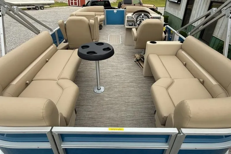 Slide: The Image of 2026 Godfrey Xperience EX2286SBX pontoon boat interior with beige seating and central table. - 4