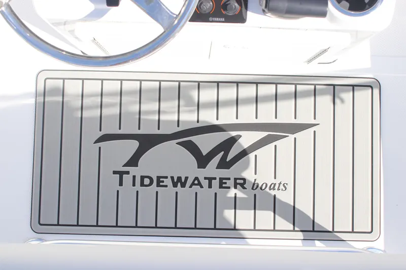 Slide: The Image of 2026 Tidewater 180 CC Adventure boat logo on deck mat, featuring steering wheel. - 15