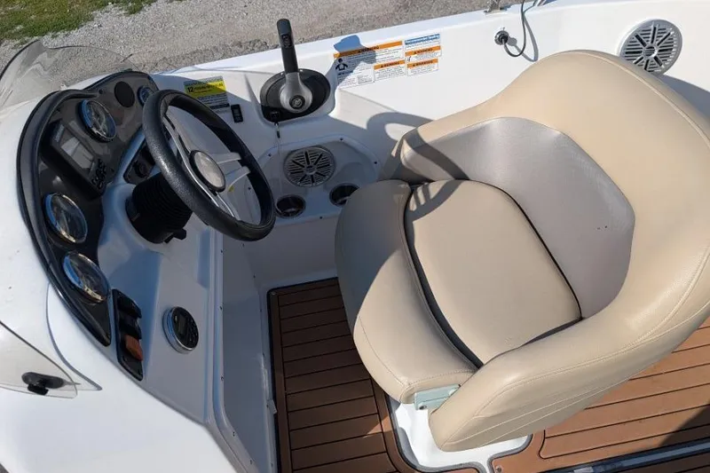 Slide: The Image of 2017 Hurricane SunDeck Sport 201 IO boat cockpit with steering wheel and beige captain's chair. - 5