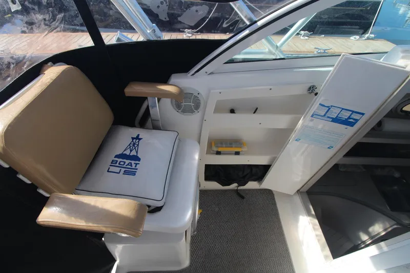 Slide: The Image of Interior of 2001 Mako 293 Walk Around boat with cushioned seating and storage compartments. - 10