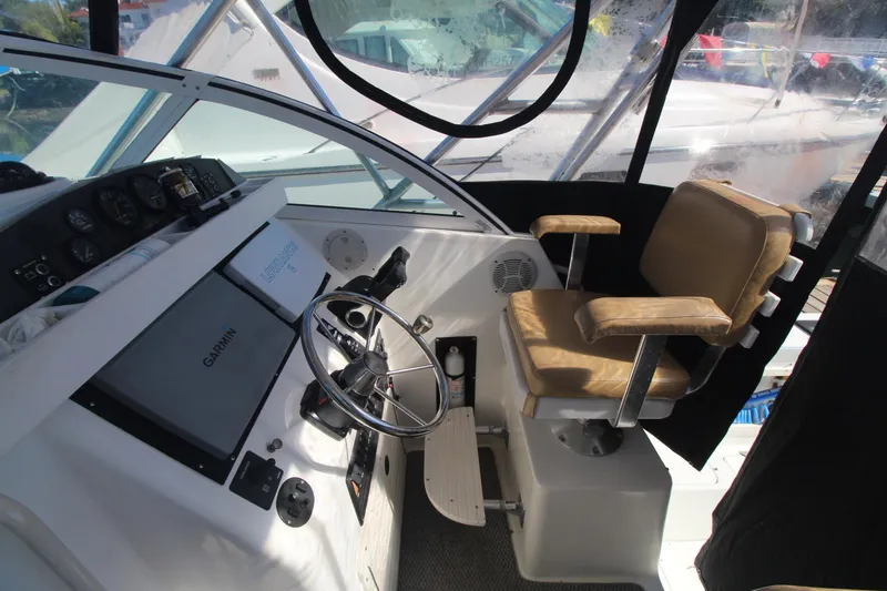 Slide: The Image of Interior of 2001 Mako 293 Walk Around boat with steering wheel and captain's chair. - 12