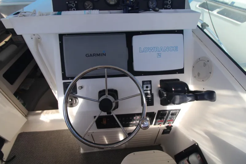 Slide: The Image of 2001 Mako 293 Walk Around boat helm with Garmin and Lowrance navigation systems. - 13