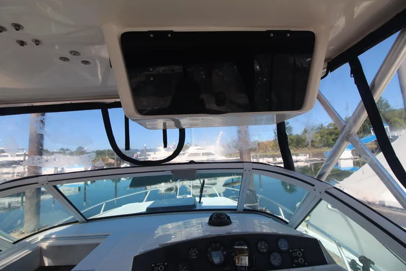 Slide: The Image of 2001 Mako 293 Walk Around boat cockpit with clear view of marina and controls. - 15