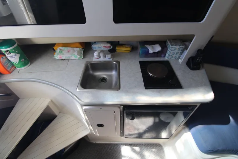 Slide: The Image of 2001 Mako 293 Walk Around boat interior with kitchenette, sink, and stove. - 20