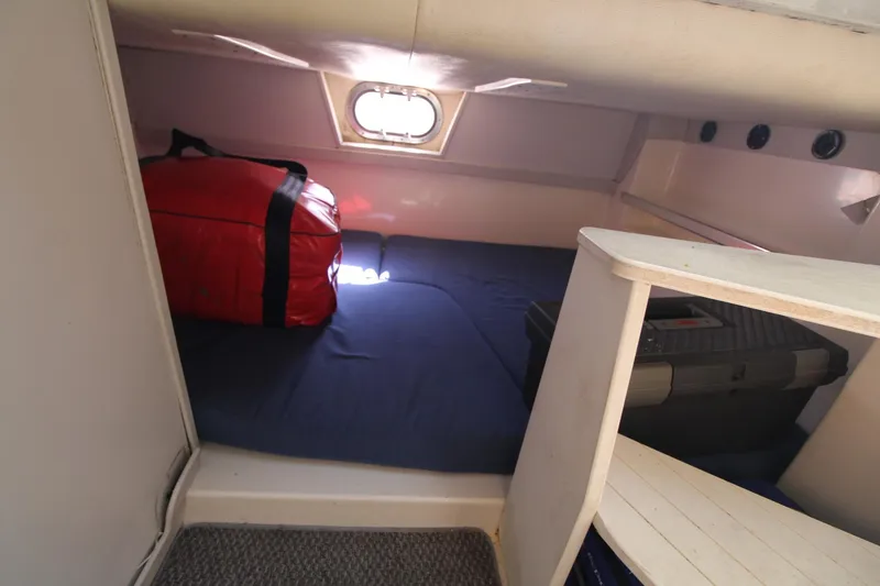 Slide: The Image of 2001 Mako 293 Walk Around cabin interior with storage and red bag. - 22