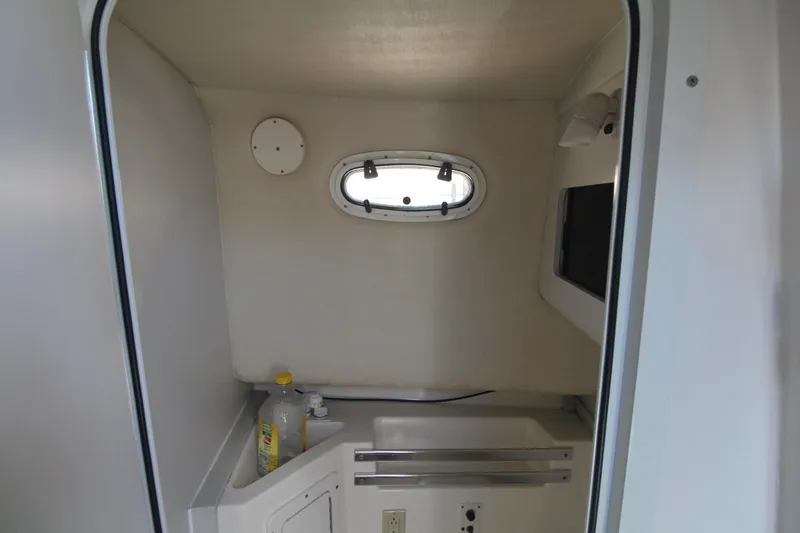 Slide: The Image of Interior of 2001 Mako 293 Walk Around boat with sink and porthole. - 23