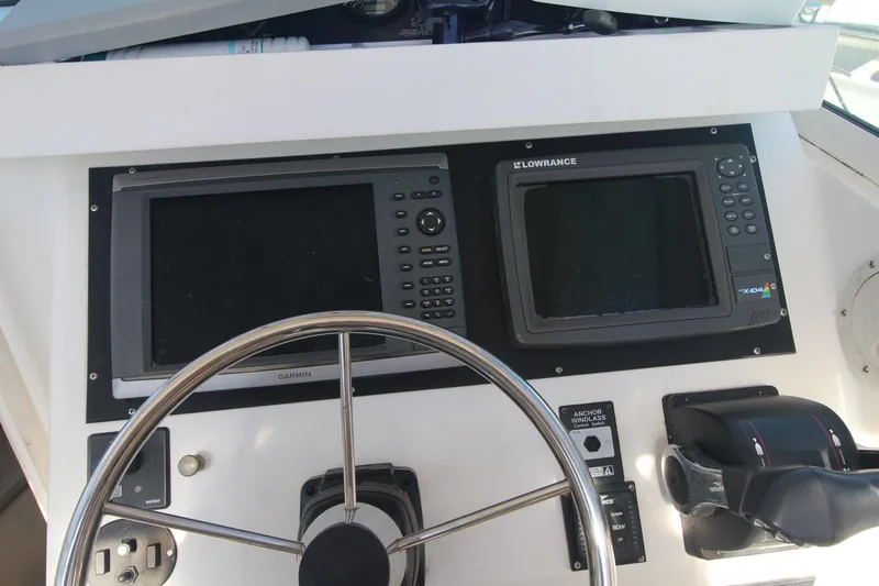 Slide: The Image of Boat dashboard of a 2001 Mako 293 Walk Around with Garmin and Lowrance displays. - 26