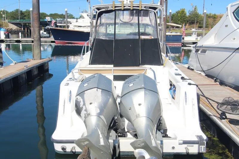 Slide: The Image of 2001 Mako 293 Walk Around boat docked with dual outboard motors. - 27