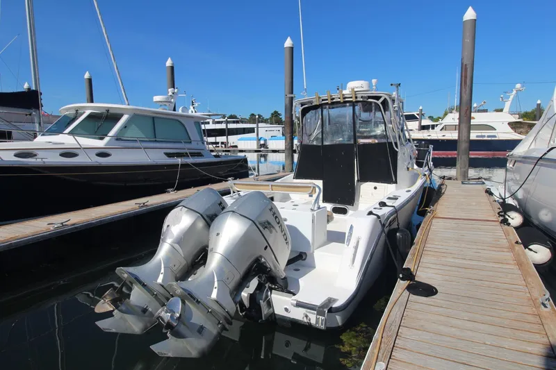 Slide: The Image of 2001 Mako 293 Walk Around boat docked with dual outboard engines. - 3