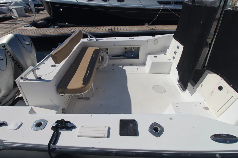 Slide: The Image of 2001 Mako 293 Walk Around boat interior with seating and Honda engines. - 5