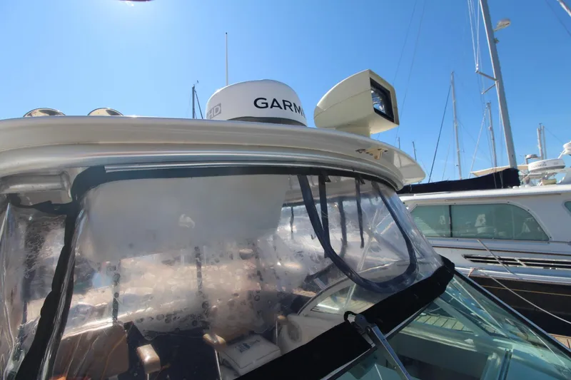 Slide: The Image of 2001 Mako 293 Walk Around boat with Garmin radar, docked under clear blue sky. - 8