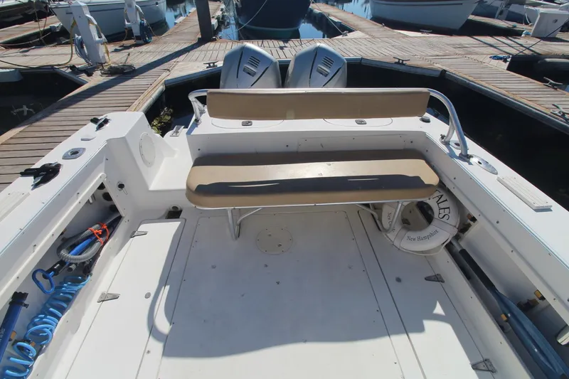 Slide: The Image of 2001 Mako 293 Walk Around boat interior with seating and docked at marina. - 9