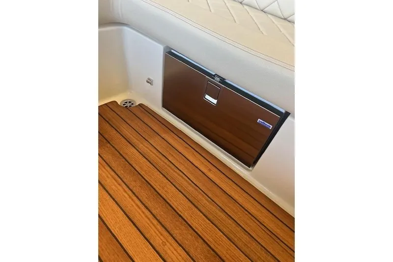 Slide: The Image of 2024 Chris-Craft Launch 27 interior with teak flooring and built-in cooler. - 10