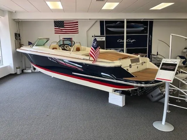 Slide: The Image of 2024 Chris-Craft Launch 27 boat on display in showroom with American flags. - 6