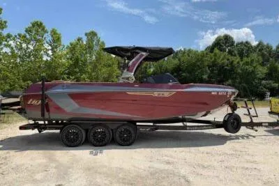 The Image of 2024 Tigé Ultré 25ZX boat on trailer, parked outdoors with trees in background. - 0