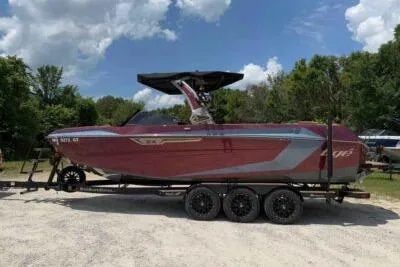 Slide: The Image of 2024 Tigé Ultré 25ZX boat on trailer, parked outdoors under a cloudy sky. - 3
