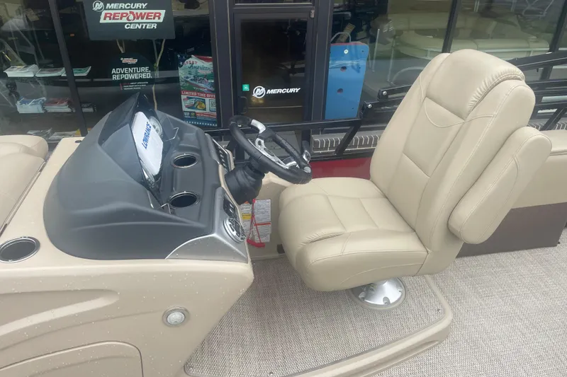 Slide: The Image of 2019 Regency 210 DL3 boat interior with beige captain's chair and steering console. - 13