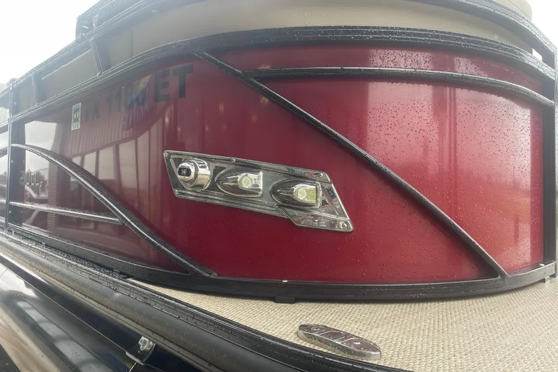 Slide: The Image of 2019 Regency 210 DL3 pontoon boat with sleek red exterior and modern design. - 2