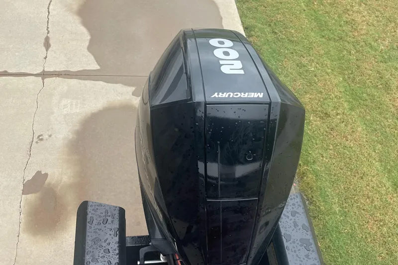 Slide: The Image of Mercury 200 outboard motor on 2019 Regency 210 DL3 boat, wet pavement and grass background. - 5